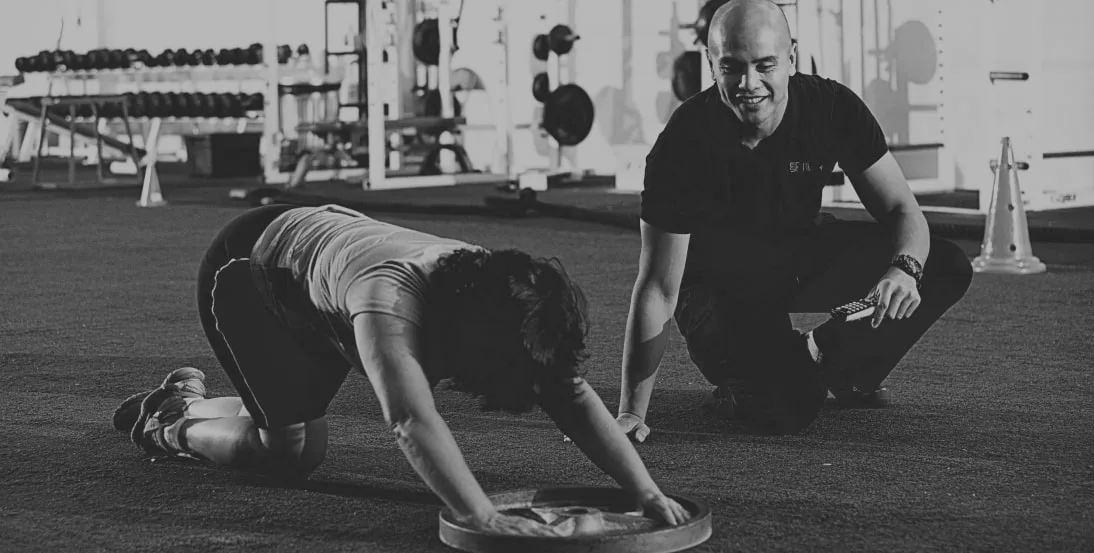 Daniel Ancheta coaching a client through a floor exercise at EDGE